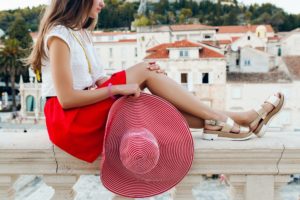pretty woman with red hat on vacation legs in sandals